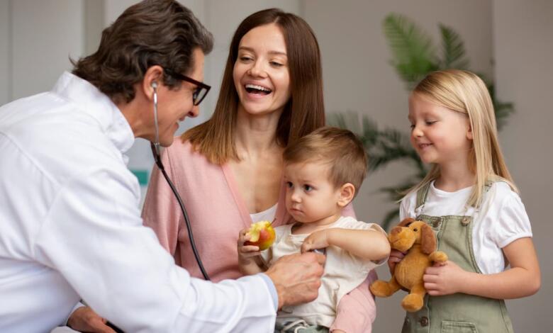Joven madre con sus hijos en cita de pediatra